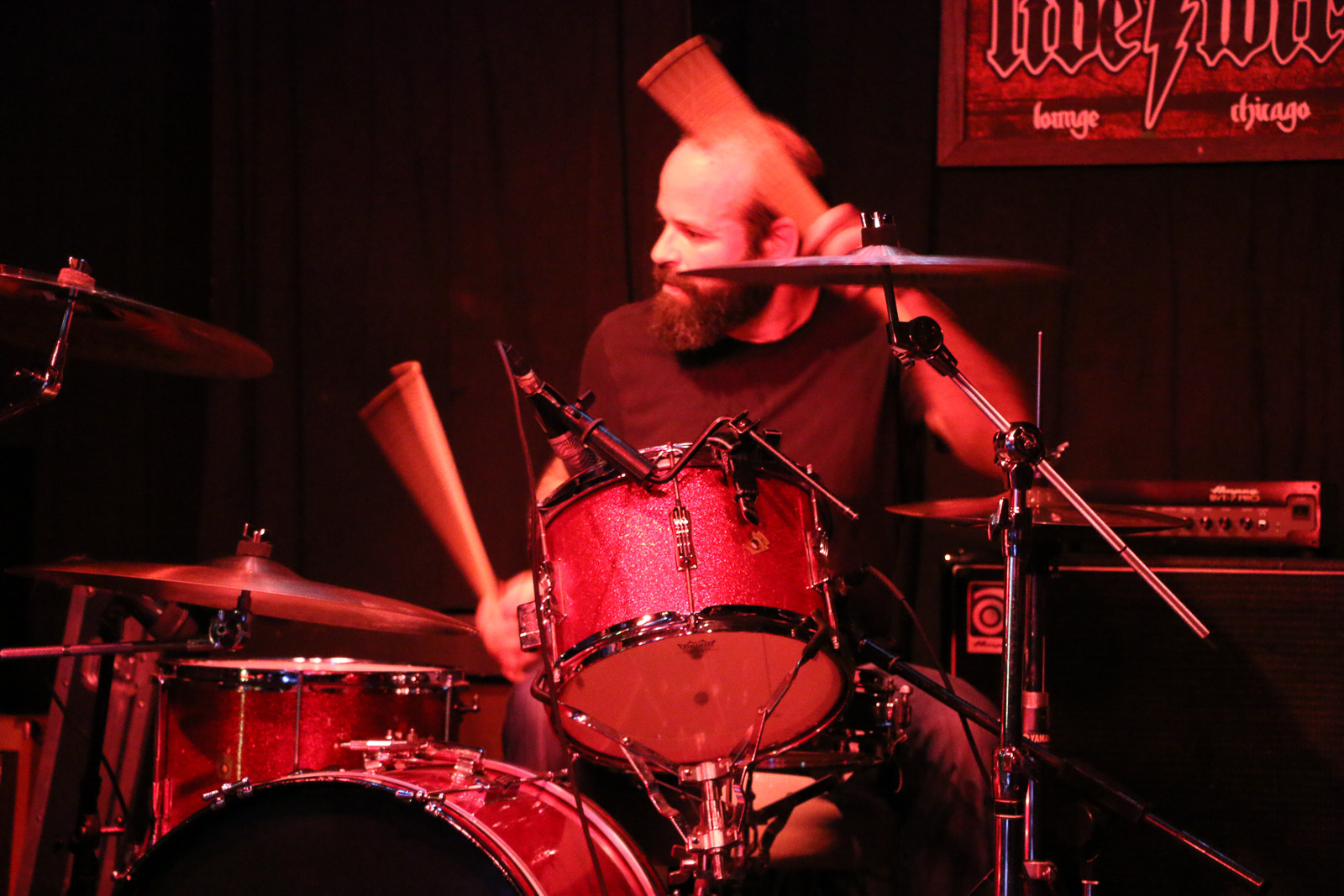 An incredibly good looking bearded man plays drums